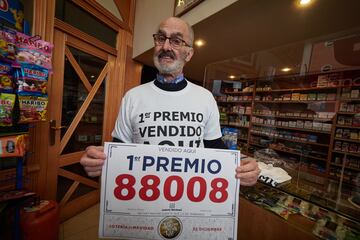 Un empleado de la administración celebra que ha vendido parte del número 88008 correspondiente al ‘Primer Premio’ del Sorteo Extraordinario de la Lotería de Navidad.