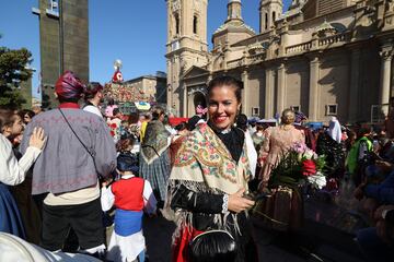 Una mujer vestida con el tradicional traje de maño durante la tradicional ofrenda de flores a la Virgen del Pilar el día de su festividad en Zaragoza, Aragón (España). Este año la ofrenda celebra su 63ª edición y se suman 11 grupos más de los que se pudieron ver en 2019, dando un total de 814 grupos participantes en el acto. Es un acto tradicional y contribuyó en gran medida a que estas fiestas se declarasen Fiestas de Interés Turístico Nacional. 
 