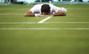 Federer lies on court after falling during his match against Raonic.