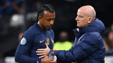 France's defender Jules Kounde (L) is consoled by France's assistant coach Guy Stephan after he was injured during the UEFA Nations League, League A Group 1 football match between France and Austria at Stade de France in Saint-Denis, north of Paris, on September 22, 2022. (Photo by FRANCK FIFE / AFP) (Photo by FRANCK FIFE/AFP via Getty Images)