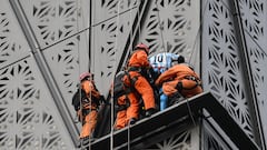 Firefighters intercept Polish climber Marcin Banot (2nd-R) as he climbed a building in Puerto Madero wearing an Argentina national football team jersey with Lionel Messi's number 10 in Buenos Aires on June 11, 2024. (Photo by LUIS ROBAYO / AFP)