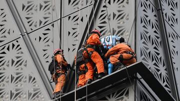 Firefighters intercept Polish climber Marcin Banot (2nd-R) as he climbed a building in Puerto Madero wearing an Argentina national football team jersey with Lionel Messi's number 10 in Buenos Aires on June 11, 2024. (Photo by LUIS ROBAYO / AFP)