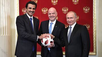 Infantino smiles as he stands next to Head of state of Qatar, Tamim bin Hamad Al Thani and Russian President Vladimir Putin.