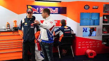 Marc Márquez en el box del Repsol Honda charlanado con el probador, Stefan Bradl.