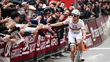 Pogacar choca la mano con aficionados a su llegada a la meta de la Strade Bianche.