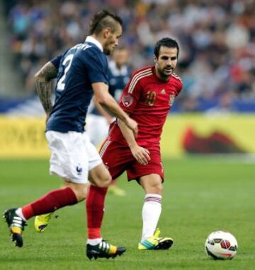 Debuchy disputa un balón con Cesc Fábregas.