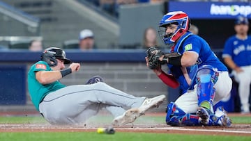 TORONTO, ONTARIO - OCTOBER 12: Cal Raleigh #29 of the Seattle Mariners is tagged out at home by Alejandro Kirk #30 of the Toronto Blue Jays during the first inning in game one of the American League Championship Series at Rogers Centre on October 12, 2025 in Toronto, Ontario. Mark Blinch/Getty Images/AFP (Photo by MARK BLINCH / GETTY IMAGES NORTH AMERICA / Getty Images via AFP)