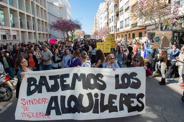 Decenas de personas durante una manifestación por la vivienda piden en una pancarta que se baje por ley el precio de los alquileres.