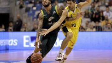 El base estadounidense de Unicaja, Marcus Williams, avanza con el balón ante la defensa del base del Club Baloncesto Canarias, Carles Biviá, durante la décimo tercera jornada de la Liga ACB que ambos equipos disputan en el Palacio de Deportes José María Martín Carpena, en Málaga.