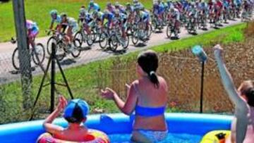 <b>FRESQUITOS. </b>Un grupo de niños interrumpe sus juegos en la piscina para aplaudir al pelotón. Fueron de los pocos que vibraron con la etapa de ayer.