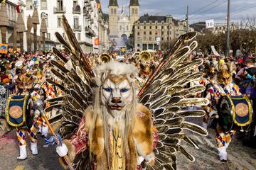 Personas vestidas con trajes tradicionales del carnaval Fritschi-Umzug asisten a un desfile para conmemorar el Jueves Gordo de Christian, en Lucerna, Suiza.