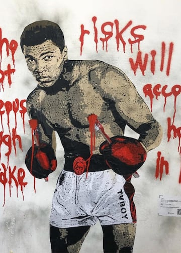 “Quien no tiene el coraje de arriesgarse, no logrará nada en la vida”. Esa es una de las frases más célebres de Muhammad Ali y, por eso, le acompaña en la obra de TVBoy. En ella se puede observar cómo las letras aún chorrean en un muro, mientras el boxeador sostiene entre sus manos dos brochas que le delatan. El mensaje refuerza la imagen de este icono del ring, retratado por otros muchos graffiteros. Sus huellas se pueden seguir por Cambridge (Massachusetts), Brooklyn (Nueva York), Camberwell (Londres)… Es más, el mismo TVBoy ya le dedicó otra pintura con anterioridad, en la que se le veía con una corona, como el 'King' Ali.