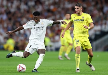 MADRID, SPAIN - OCTOBER 05: Vinicius Junior of Real Madrid scores his team's second goal under pressure from Santi Comesana of Villarreal CF during the LaLiga match between Real Madrid CF and Villarreal CF  at Estadio Santiago Bernabeu on October 05, 2024 in Madrid, Spain. (Photo by Gonzalo Arroyo Moreno/Getty Images)