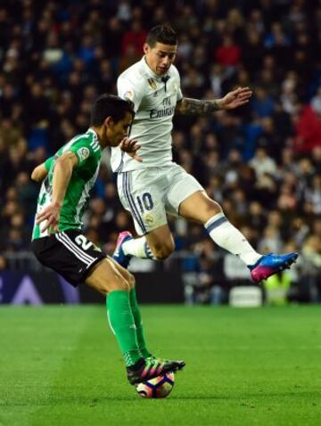 Real Madrid's Colombian midfielder James Rodriguez (R) vies with Betis' Serbian midfielder Aissa Mandi during the Spanish league footbal match Real Madrid CF vs Real Betis at the Santiago Bernabeu stadium in Madrid on March 12, 2017. / AFP PHOTO / GERARD 