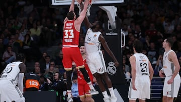 Olympiacos Piraeus' Serbian center #33 Nikola Milutinov dunks in spite of Real Madrid's Spanish center #16 Usman Garuba during the Euroleague basketball match between Real Madrid Baloncesto and Olympiakos Piraeus at the Wizink Center arena in Madrid on January 16, 2025. (Photo by Thomas COEX / AFP)