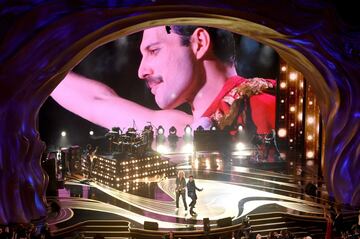 Adam Lambert y Brian May de Queen con una imagen de Freddy Mercury.