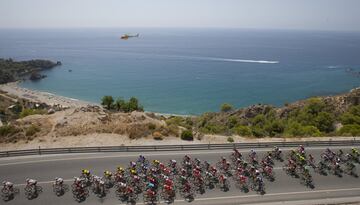 El pelotón pasa por una carretera frente al mediterráneo.