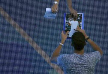 El b¨²lgaro Grigor Dimitrov firma un aut¨®grafo sobre una foto de Roger Federer.