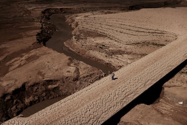 Un hombre camina sobre el suelo agrietado del embalse de Baells, una infraestructura hidráulica española situada en el río Llobregat, en la comarca del Bergadá, provincia de Barcelona. 