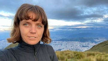 Lucy Small, selfie en la montaña, con una ciudad al fondo.