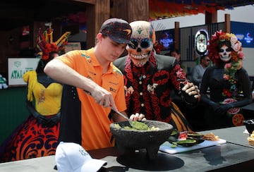 Oscar Piastri cocina guacamole junto a una persona vestida de catrín previo al GP de México.