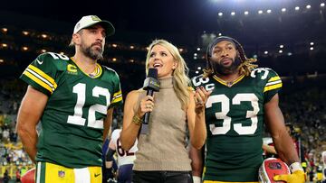 GREEN BAY, WISCONSIN - SEPTEMBER 18: Aaron Rodgers #12 and Aaron Jones #33 of the Green Bay Packers talk to a reporter on the field after a win over the Chicago Bears at Lambeau Field on September 18, 2022 in Green Bay, Wisconsin. Michael Reaves/Getty Images/AFP