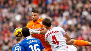 SEVILLA , 16/03/2025.- El portero del Athletic Unai Simón (detrás) atrapa el balón durante el partido de LaLiga entre el Sevilla y el Athletic Club, este domingo en el estadio Ramón Sánchez Pizjuán. EFE/ Julio Muñoz