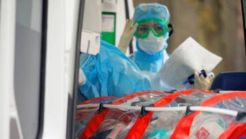 A medical employee wears a protective suit as a capsule with a woman inside is loaded into an ambulance as a measure to fight against the coronavirus disease contagion (COVID-19) in Minsk, Belarus March 12, 2020.  REUTERS/Vasily Fedosenko