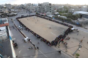 Un grupo de palestinos juega al f¨²tbol en un campo de arena en Rafah, antes de romper el ayuno por el Ramad¨¢n, ante la mirada de un gran n¨²mero de espectadores. Rafah es una localidad pr¨®xima a la frontera de Egipto. Es la capital de distrito de la Gobernaci¨®n de Rafah, situada a 30 kil¨®metros al sur de la ciudad de Gaza.