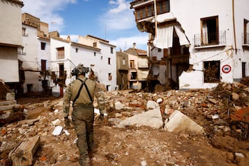 Un miembro de la unidad militar española UME camina sobre los escombros después de que las fuertes lluvias provocaran inundaciones, en Letur, España.