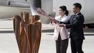 MATSUSHIMA, JAPAN - MARCH 20: Olympic gold medalists Tadahiro Nomura (R) and Saori Yoshida (L) light the Olympic flame during the Tokyo 2020 Olympic Games Torch Arrival Ceremony at the Japan Air Self-Defense Force Matsushima Air Base on March 20, 2020 in