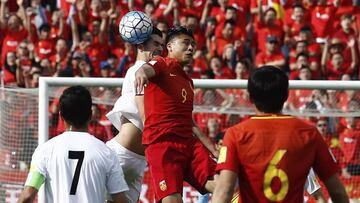 Saeid Ezatollahi Y Zhan Yuning, en el Irán-China. Al fondo, aficionados chinos animan a su selección.
