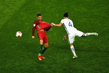 Cristiano Ronaldo sujetado por Mauricio Isla de Chile durante la semifinal de la Copa Confederaciones en Rusia