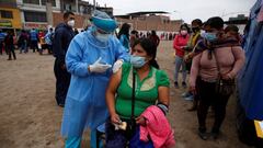 A woman gets vaccinated as others wait in line during a vaccination drive for diphtheria, influenza, tetanus and pneumococcus after several new cases of diphtheria were identified, as the coronavirus disease (COVID-19) outbreak continues, in Lima, Peru November 7, 2020. REUTERS/Sebastian Castaneda