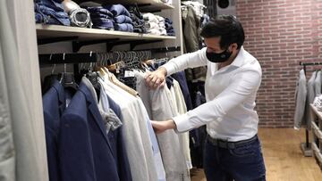 Un hombre protegido con una mascarilla realiza unas compras en una tienda en Madrid. EFE/Rodrigo Jim&eacute;nez/Archivo