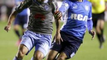 Lisandro López pelea con Walter Flores por un balón.