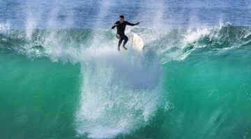 Un surfista cae de su tabla en Newport Beach, California.