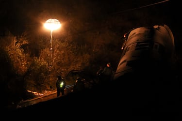 Personal de emergencia trabaja junto a un vagón descarrilado en el lugar del descarrilamiento mortal de dos trenes de alta velocidad cerca de Adamuz, en Córdoba, España.