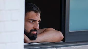 Giorgi Mamardashvili mira el partido desde una ventana.