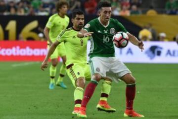 Héctor Herrera y Tomás Rincón pelean por el esférico.