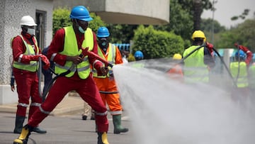 Fire service crews decontaminate a street in Abuja, Nigeria.