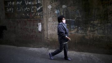 A woman, wearing a protective face mask to help curb the spread of the new coronavirus, walks past in the Villa 31 slum during a government-ordered shutdown, in Buenos Aires, Argentina, Thursday, April 30, 2020. According to official data, the number of confirmed cases of COVID-19 in the city's slum have increased in the past week, putting authorities on high alert. (AP Photo/Natacha Pisarenko)