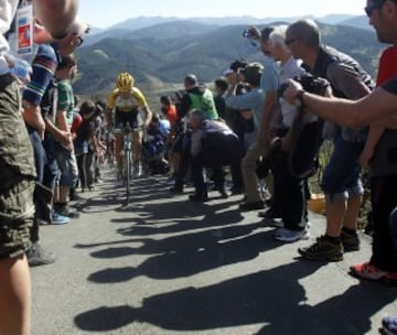 Varios ciclistas se abren paso entre la gente hoy en el Alto de La Antigua, en la localidad guipuzcoana de Zumarraga, durante la tercera etapa de la 55 edición de la Vuelta al País Vasco.