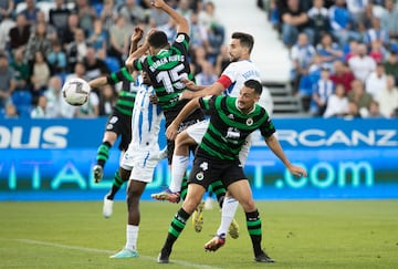 Pol Moreno y Rubén Alves, del Racing, peleando con Juan Muñoz, del Leganés.