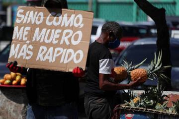 A man holds up a placard reading "If I don't eat, I die faster" in front of the central market as he protests against the measures taken by the government, during the outbreak of the coronavirus disease (COVID-19), in Santo Domingo, Dominican Republic Apr