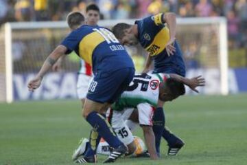 El jugador de Boca Juniors Nicolas Colazzo, izquierda disputa el balon con Leonardo Valencia de Palestino durante el partido del grupo 5 de la Copa Libertadores en el estadio Santa Laura de Santiago, Chile.