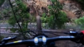 El rider de MTB Tommo, con su bici, cayendo sobre las v&iacute;as del tren en las que tuvo un grave accidente. 