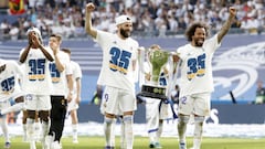 Benzema y Marcelo, con el trofeo de campeones de Liga sobre el c&eacute;sped del Bernab&eacute;u.