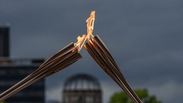 HIROSHIMA, JAPAN - MAY 17: The atomic bomb dome stands in the background as Tokyo 2020 Olympic torch bearers exchange the flame during the torch relay in the Hiroshima Peace Park on May 17, 2021 in Hiroshima, Japan. (Photo by Carl Court/Getty Images)