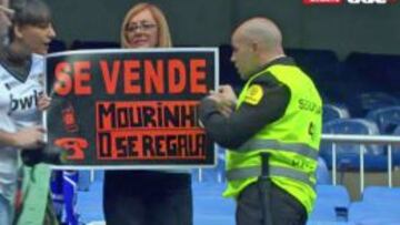 Los servicios de seguridad del Bernabéu retiran una pancarta contra Mourinho.